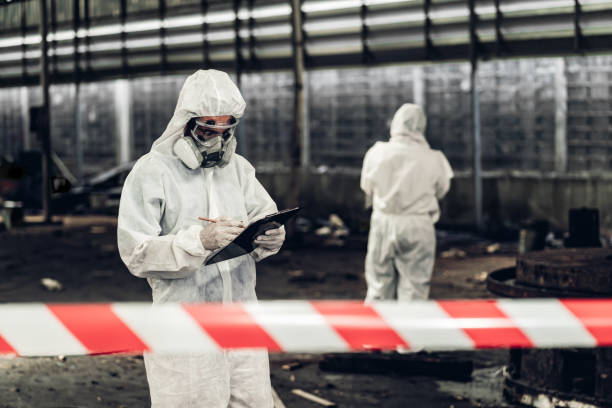 Scientist wear Chemical protection suit check danger chemical, working at dangerous zone in Red and White Lines of barrier tape. Red and white Hazardous restricted area factory safety worker industry el científico usa traje de protección química para verificar el peligro químico, trabajando en una zona peligrosa en líneas rojas y blancas de cinta de barrera. rojo y blanco industria de trabajadores de seguridad de fábrica en áreas restringidas pe