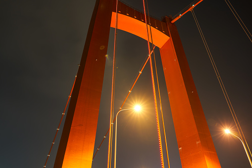 Close-up night view of the bridge across the river in the city