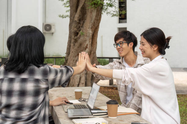 istock Students putting their hands together. Concept of teamwork and partnership 1504928319