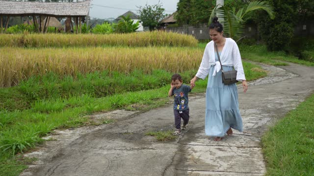 a mother and son in a rice paddy field