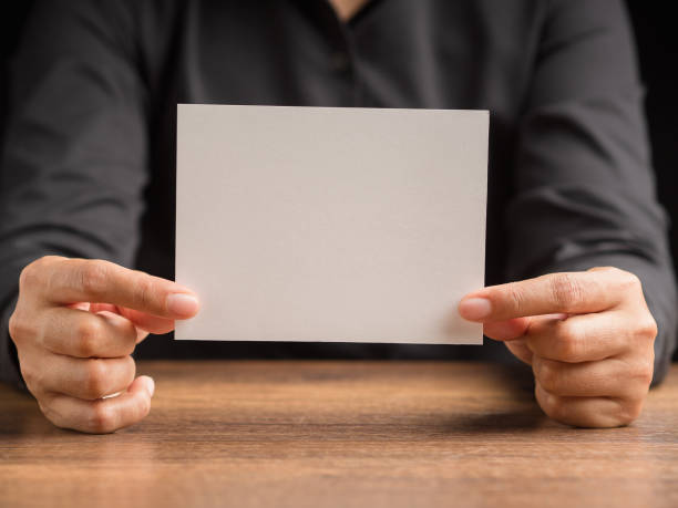 istock Hand holding of a blank paper while sitting in the office 1504977497