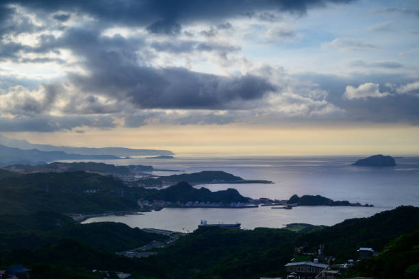 istock A village surrounded by mountains and sea. Blue sky and colorful dynamic clouds. 1504986929