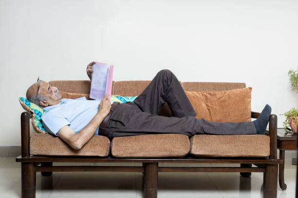 Student rests with a book on wooden bench in the summer. No stress