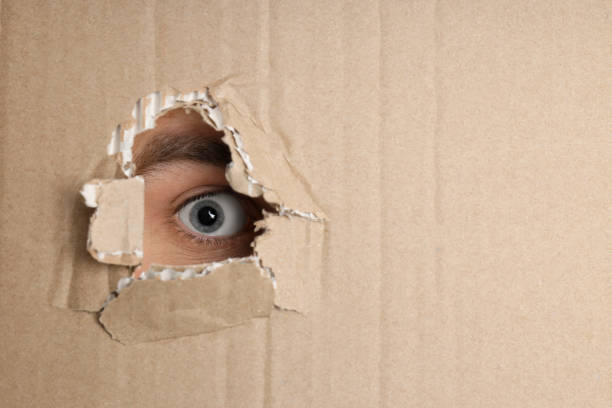 istock Cardboard with hole with female eye, close up 1504991450