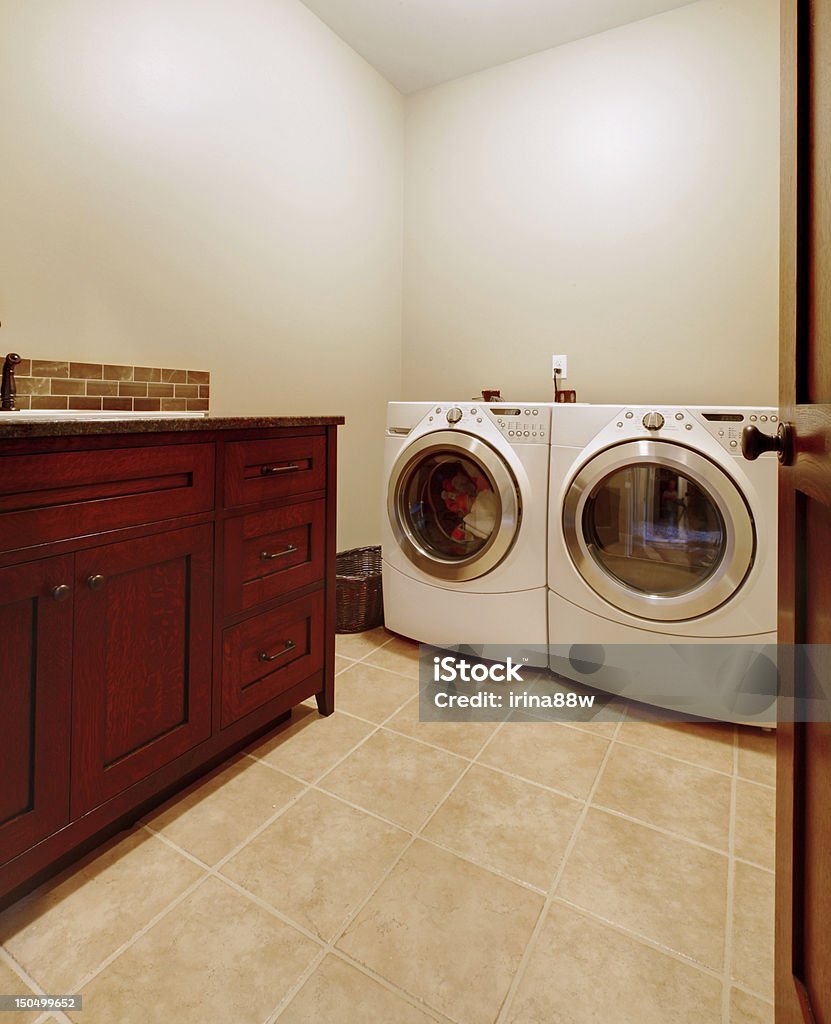 Laundry room with wood cabinets and new appliances. Simple new laundry room with new washer and dryer and wood cabinet. Appliance Stock Photo