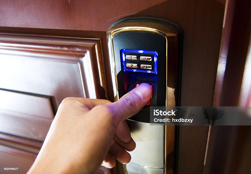 Lady using thumbprint technology to open a door An hand is going to open a door. Accessibility Stock Photo