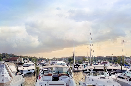 evening light over water and expensive sailboats and motorboats  in a coastal long island town