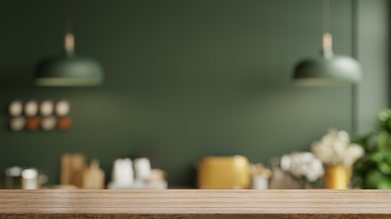 Tablero de mesa de madera sobre fondo borroso de la sala de cocina, interior de la sala de cocina verde contemporánea moderna. photo