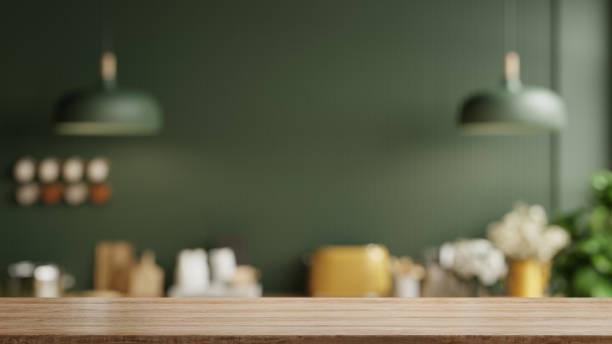 piano del tavolo in legno sullo sfondo della stanza della cucina sfocata, interno della cucina verde moderna contemporanea. - fornello foto e immagini stock