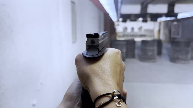 Personal Perspective of a Woman Shooting with a Handgun in Shooting Range