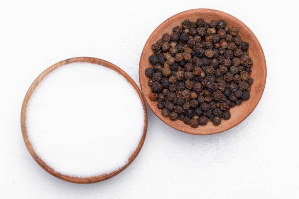 istock Table salt and black pepper in grains in a bowl, on a white background 1505128495