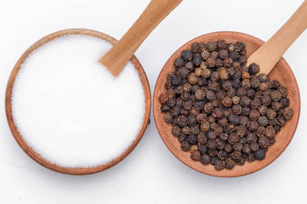 istock Salt and pepper in two wooden bowls on a white background 1505129060