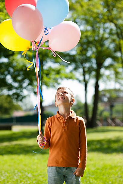 istock Little Boy Holding Balloons 150514751