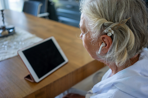 women is looking mobile device ear phone is in ear horizontal still