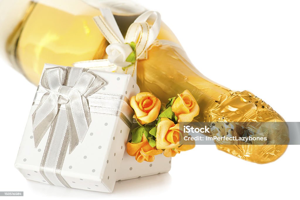 Champagne bottle, present box with bow and flower boutonniere Champagne bottle, present box with bow and flower boutonniere on white background Alcohol - Drink Stock Photo