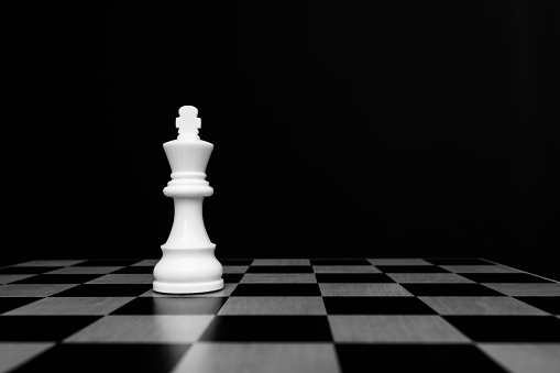 White king chess piece on chess board.