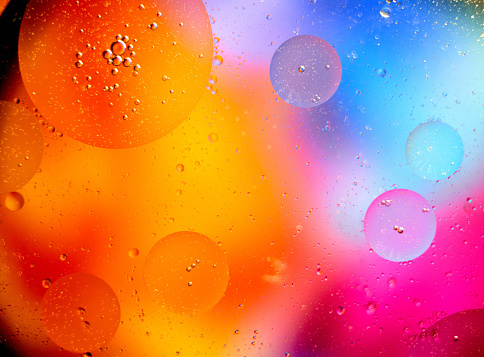 Beautiful abstract background from mixed water and oil in orange and purple color. Abstract macro background. Desktop wallpaper. Texture. Colored bubbles.