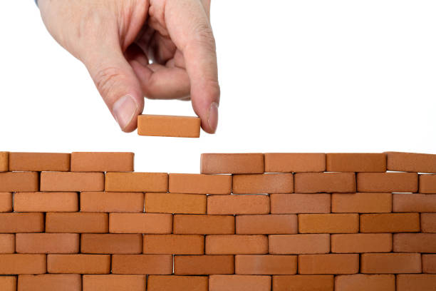 istock Man putting toy brick onto a wall 1505184492