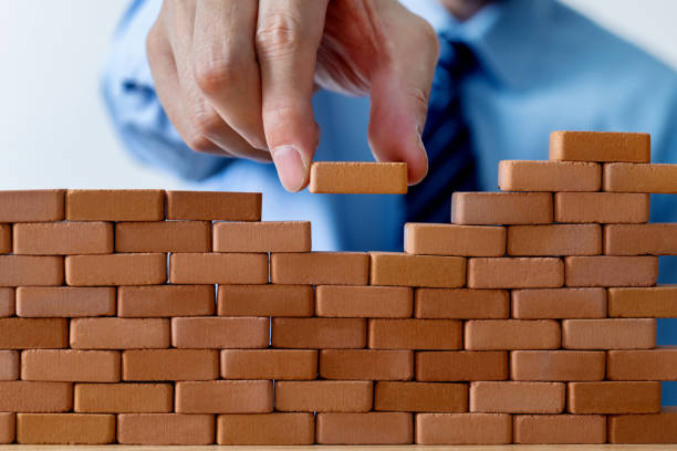 istock Businessman putting toy brick onto a wall 1505185085