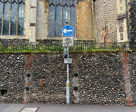 Dirty cycle route sign by a church in Norwich