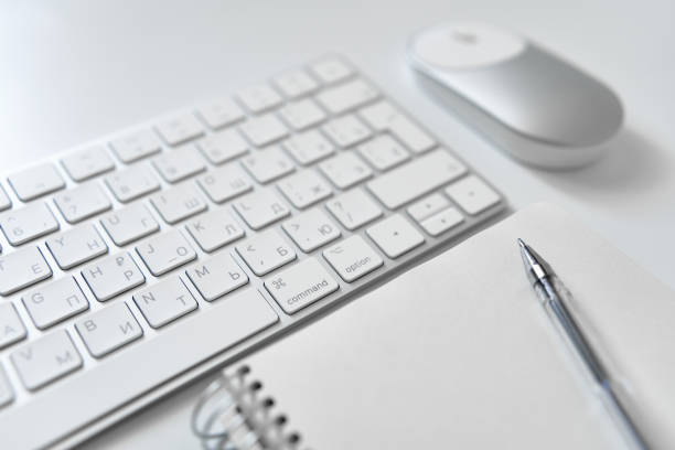 istock Office table desk. Workspace with sketchpad, keyboard, office supplies, pencil, on white table. 1505212355