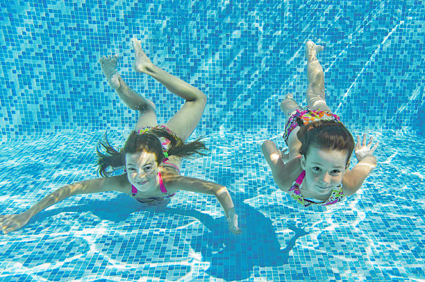 istock Happy smiling underwater children in swimming pool 150521897