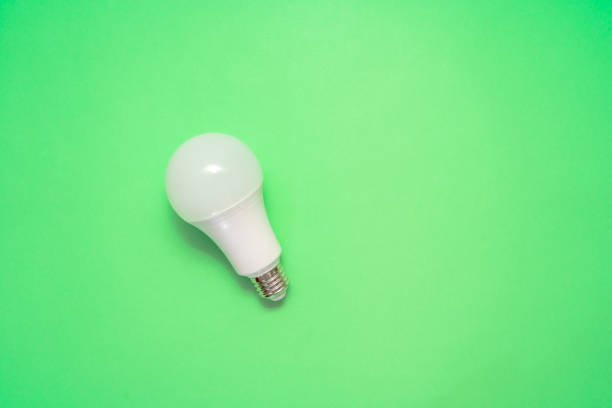 istock Energy saving light bulb on green background. Savings 1505221298