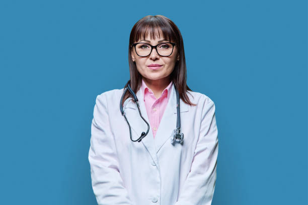 istock Portrait serious female doctor looking at camera, on blue background 1505228651