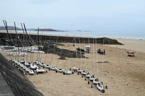 Saint-Malo, France, june 28, 2023 : Sand yachts from the Surf School and catamarans on the Hoguette beach in Saint-Malo