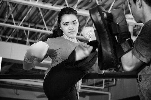 Photo of a female boxer sitting in a boxing ring corner.