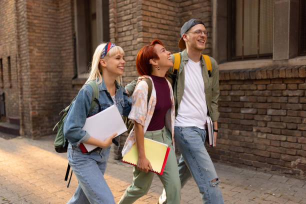 istock Cheerful university friends walking in front of school building. 1505246143