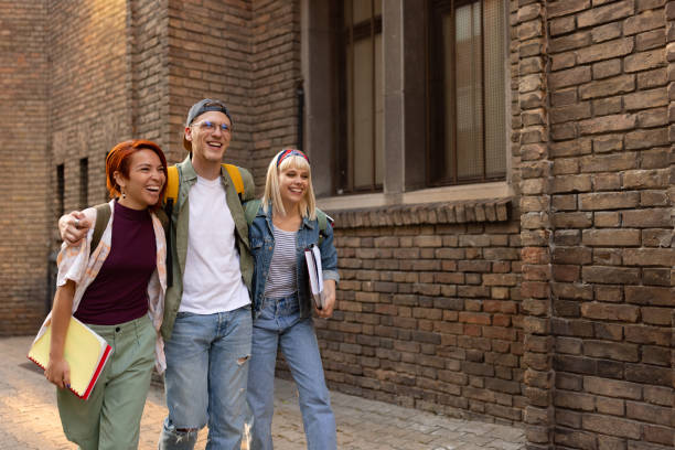 Happy embraced students taking a walk on the street.