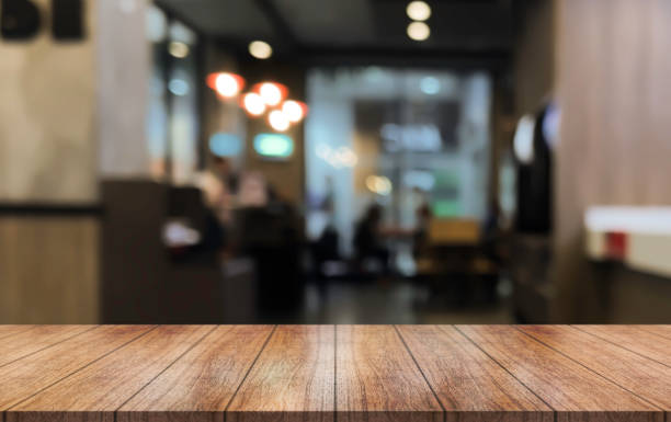istock Empty wooden table top with lights bokeh on blur restaurant background. 1505262298
