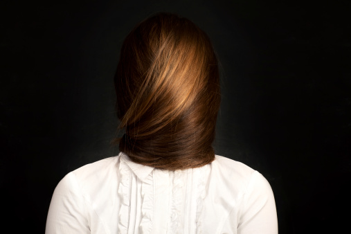 Сonceptual photo of young woman with very long hair which covers her face.