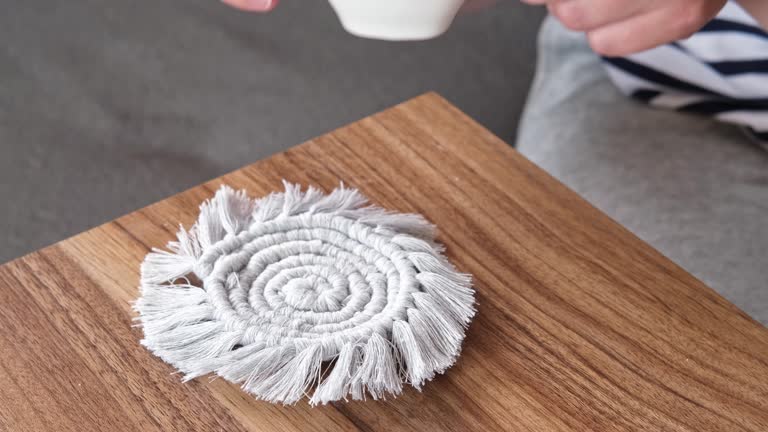 Young female friends-colleagues chat over a cup of hot tea on the couch. A cup of tea stands on a do-it-yourself knitted stand