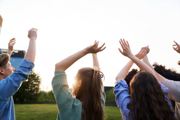 istock Back view of group of young people with hands raised 1505277370