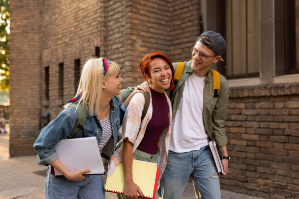 istock Cheerful embraced students talking while walking on the street. 1505290414