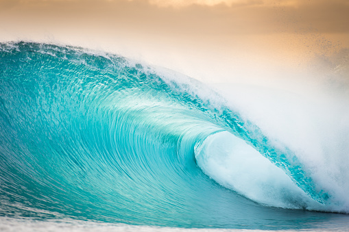 A gorgeous transparent blue barrel at sunset by the Mentawai islands of Indonesia begging to be surfed.