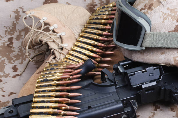 istock US MARINES. Machine gun with ammunition belt and armor helmet with protective goggles on uniform background. 1505307609