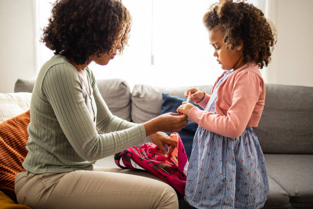 istock Mother helping her daughter to get ready for school 1505316060