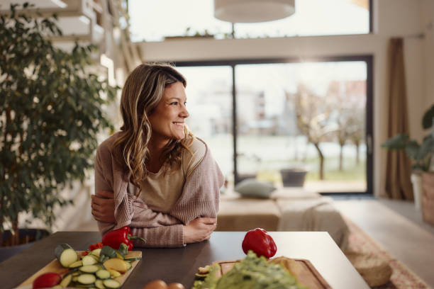 Happy woman day dreaming in the kitchen.