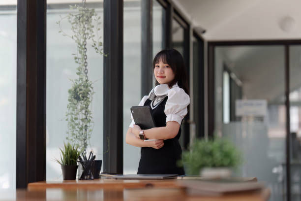 istock Online education, e-learning. Asian woman in stylish casual clothes, studying using a laptop, listening to online lecture, taking notes, online study at home 1505327258