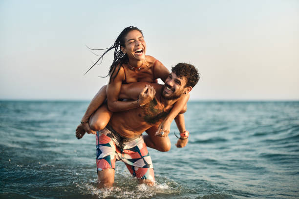 istock Cheerful couple having fun while piggybacking at sea. 1505334809