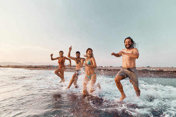 istock Cheerful friends running through sea in summer day. 1505344049
