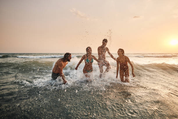 istock Cheerful couples having fun during their summer vacation in sea at sunset. 1505344626