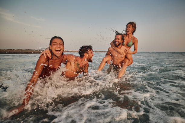 istock Young cheerful couples having fun during summer vacation in sea. 1505345509