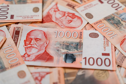 Pile of Serbian dinar banknotes. Heap of red thousand dinars bills.
