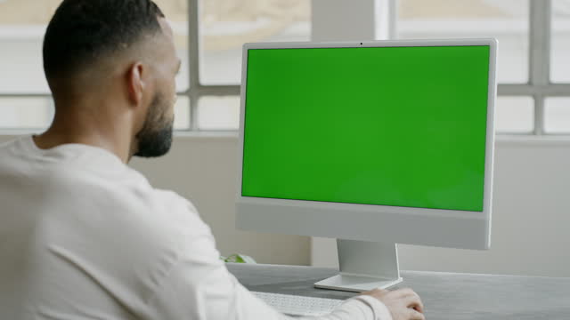 A man is sitting at his desk with green screen. Stock video