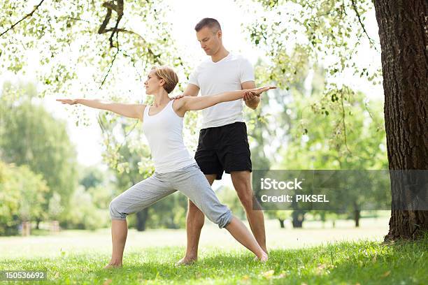 Couple Practicing Yoga In The Park Stock Photo - Download Image Now - Couple - Relationship, Fun, Yoga