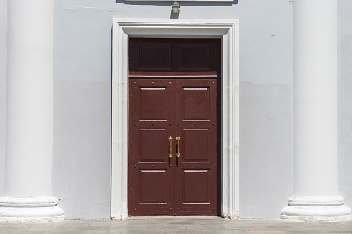 wooden old door. Entrance to the theatre. Building with columns and a brown door.